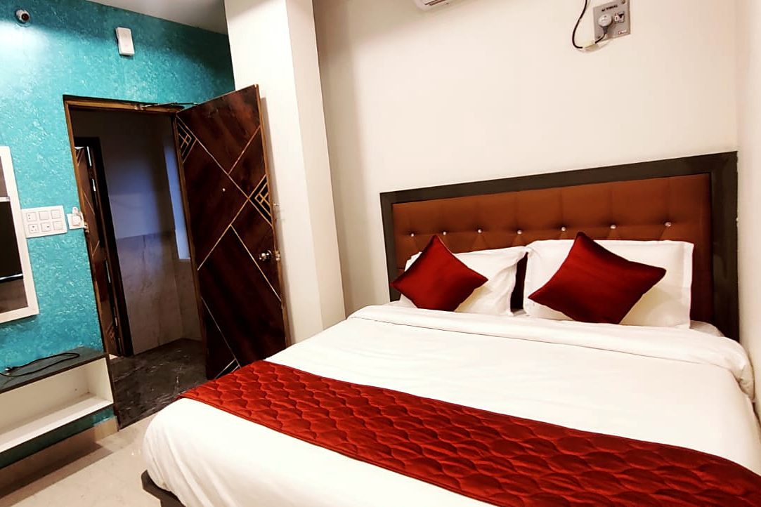 Queen Room at Aadya Inn Tirupati with a double bed and wall-mounted TV