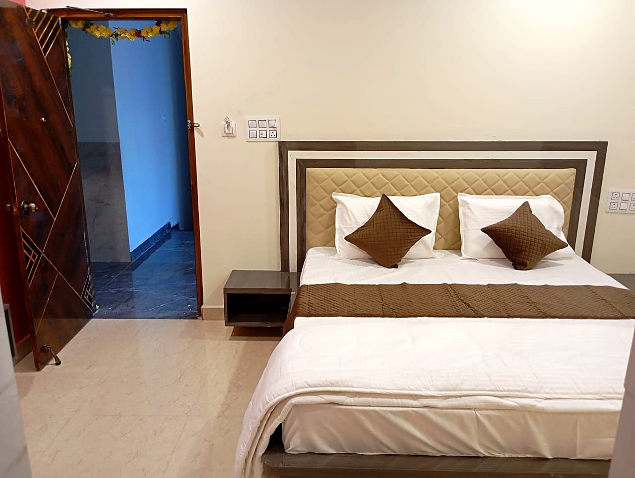 King Room bed seen from the foot, with the room door