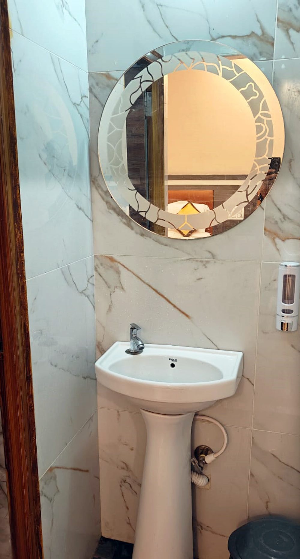 Bathroom wash basin and mirror at Aadya Inn Tirupati