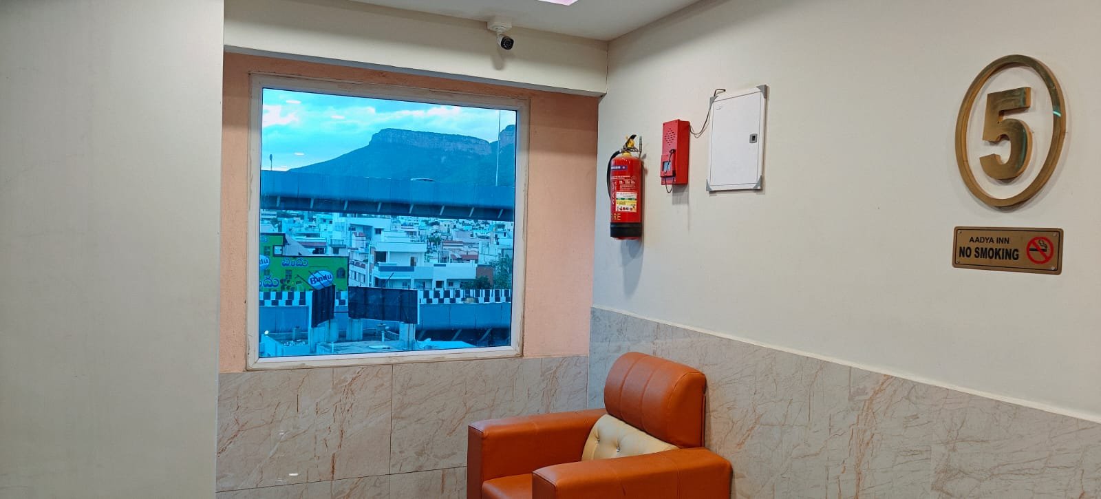 Fifth floor seating with a view of the Tirumala hills at Aadya Inn